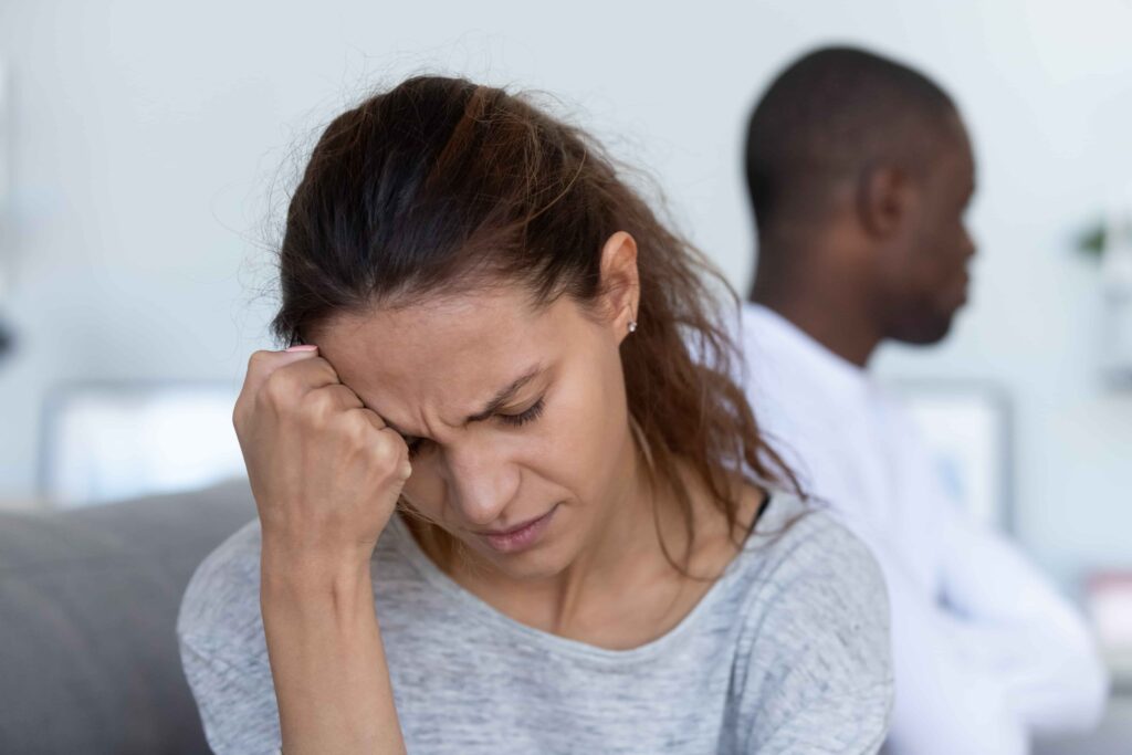 Distressed person with another in background, capturing a moment of tension or conflict